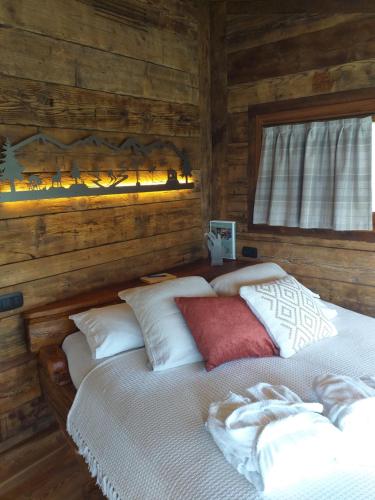 um quarto com uma cama num chalé de madeira em SKYLODGE 'il Rifugio dell'Anima' em Usseglio
