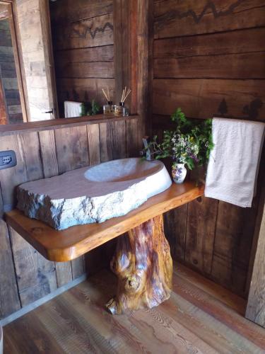 a wooden bathroom with a tree stump sink at SKYLODGE 'il Rifugio dell'Anima' in Usseglio