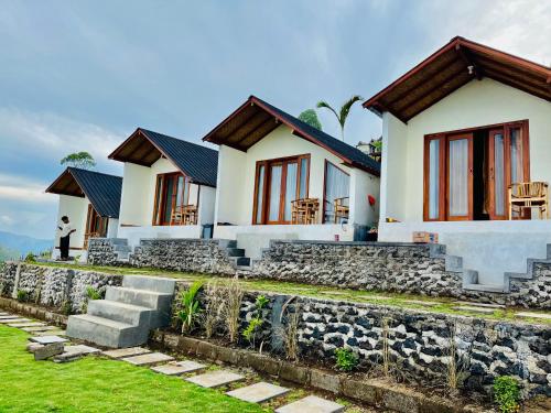 a house with a stone wall in front of it at Bali Sunrise Cabin in Bangli