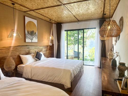 a hotel room with two beds and a window at Vayang Retreat and Camping in Hòa Bình