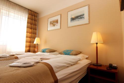 a hotel room with two beds and a window at Hotel Marttel in Karlovy Vary