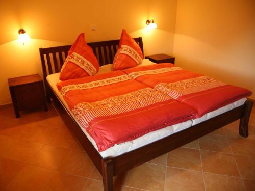 a bed with red pillows on it in a room at Exkl App Strandmuschel, Kamin, 250 m zum Strand in Börgerende-Rethwisch