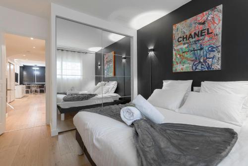 a bedroom with a large white bed and a mirror at L'élégant Maubourg - Next Hotel Martinez -Terrasse in Cannes