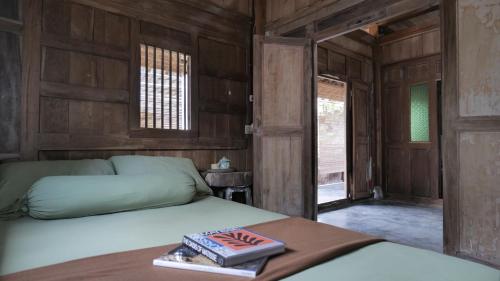 um quarto com 2 camas com paredes e janelas de madeira em Serambut Widi Artcation em Yogyakarta