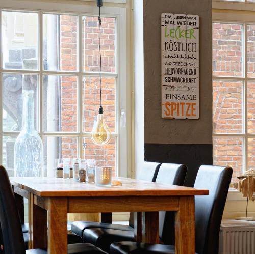 a dining room with a wooden table and chairs at Restaurant Haus Hamburg in Leer
