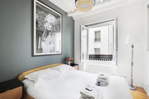 une chambre avec un lit blanc et une fenêtre dans l'établissement Apartments in the heart of Paris in Sentier, à Paris