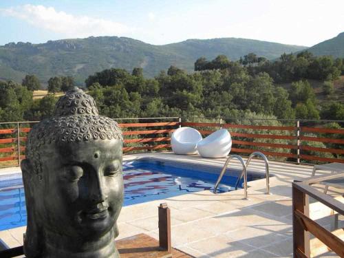une statue d'une tête à côté d'une piscine dans l'établissement El Refugio de Cristal, à Hontanar