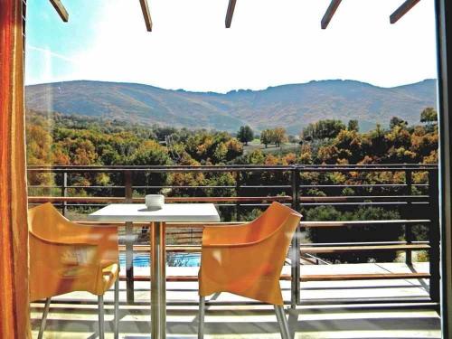 una mesa y sillas en un balcón con vistas en El Refugio de Cristal, en Hontanar
