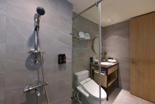 a bathroom with a shower and a toilet and a sink at Fullon Poshtel - Kaohsiung in Kaohsiung