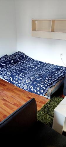 a bedroom with a bed with a blue comforter at Garsonjera in Zagreb