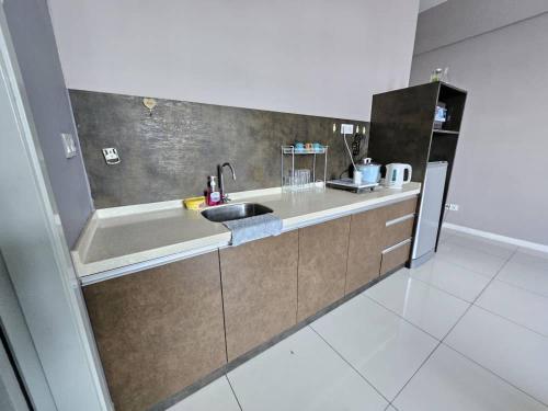a kitchen with a sink and a refrigerator at Cantara Escape Lily in Kota Kinabalu