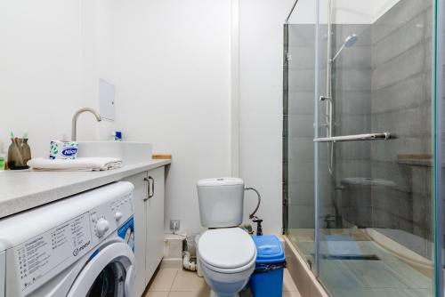 y baño con lavadora y ducha. en 2 комнатная квартира в сердце города - цокольный этаж en Almaty
