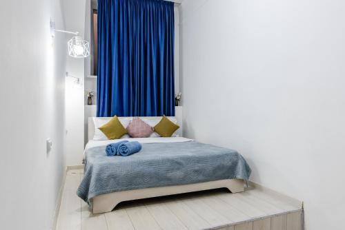 1 dormitorio con 1 cama con mantas y almohadas azules en 2 комнатная квартира в сердце города - цокольный этаж en Almaty