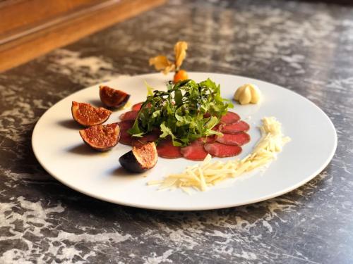 a white plate with food on a table at Familie Hopfeld - Hotel Dreikönigshof in Stockerau