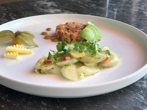 a plate of food with potatoes and vegetables on a table at Familie Hopfeld - Hotel Dreikönigshof in Stockerau