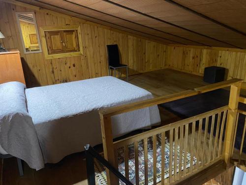 a bedroom with a bed in a wooden cabin at Viviendas Rurales del Robledo in Castaño de Robledo