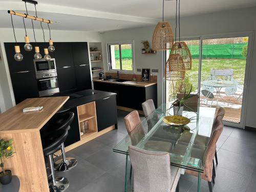 une cuisine et une salle à manger avec une table en verre dans l'établissement Comme à la maison, à Neuvy-Sautour