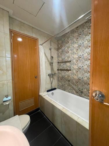 a bathroom with a bath tub and a toilet at Homes at Bay Area Suites by SMS Hospitality in Manila