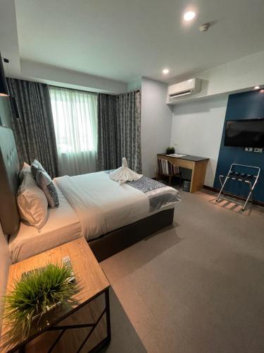 Homes at Bay Area Suites by SMS Hospitality في مانيلا: غرفة فندقية بسرير كبير وطاولة