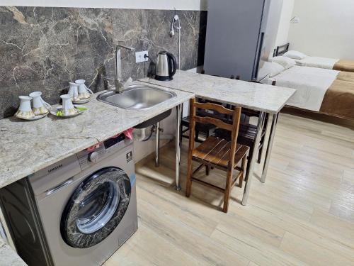 a kitchen with a sink and a washing machine at GUEST HAUSE & HOSTEL 15a in Kʼutʼaisi