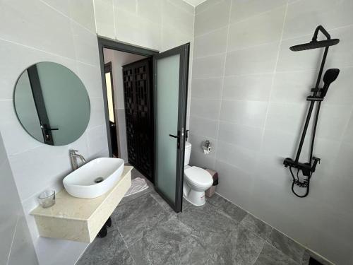 a bathroom with a sink and a toilet and a mirror at Sky Home in Ấp Khánh Phước (1)