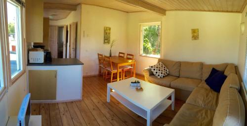ein Wohnzimmer mit einem Sofa und einem Tisch in der Unterkunft Vinbergs Stugby in Vinberg