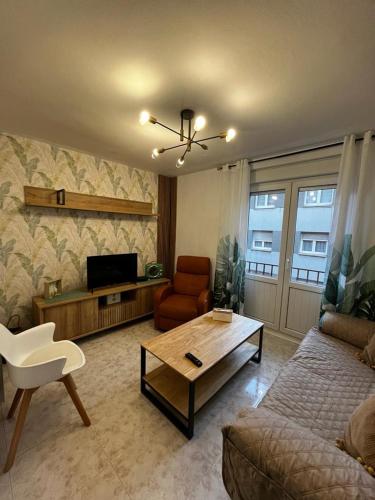 een woonkamer met een bank en een salontafel bij Precioso piso totalmente reformado. in Gijón