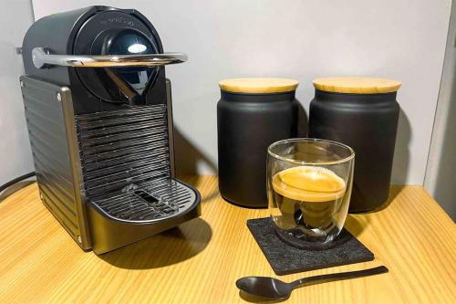 a coffee maker and a glass of coffee on a table at -The Urbanist- Mountainview Parking Garden 3BD in Unterseen