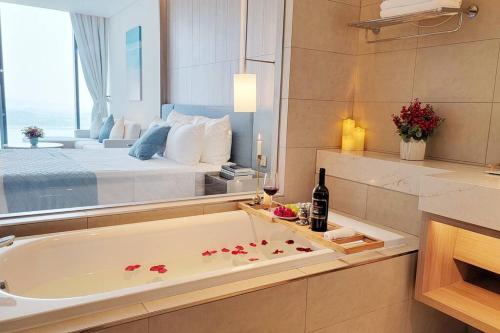 uma casa de banho com banheira e uma cama ao fundo em Modern 5-star ALa Carte Condo apartment 29th08 em Ha Long