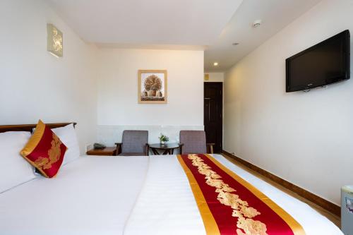 ホーチミン・シティにあるKing Hotel Saigon Airportのベッド1台、薄型テレビが備わるホテルルームです。