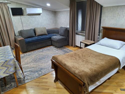 a hotel room with a bed and a couch and a couch at GUEST HAUSE & HOSTEL 15a in Kʼutʼaisi