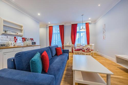 ein Wohnzimmer mit einem blauen Sofa und einem Tisch in der Unterkunft Apartamenty House Managers - Bursztynowa Zatoka in Sopot