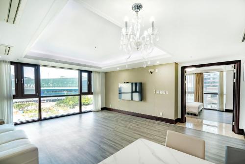 a living room with a chandelier and large windows at Centum Convention Hotel In Centum in Busan