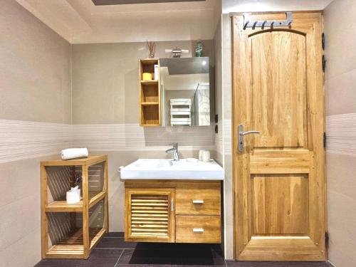 baño con lavabo y puerta de madera en Le Bellavista- Centre - Proche Aiguille du Midi, en Chamonix-Mont-Blanc
