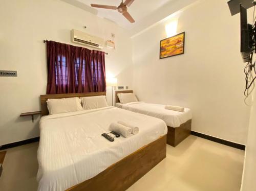 sypialnia z 2 łóżkami i wentylatorem sufitowym w obiekcie La Paradise Residency w mieście Puducherry