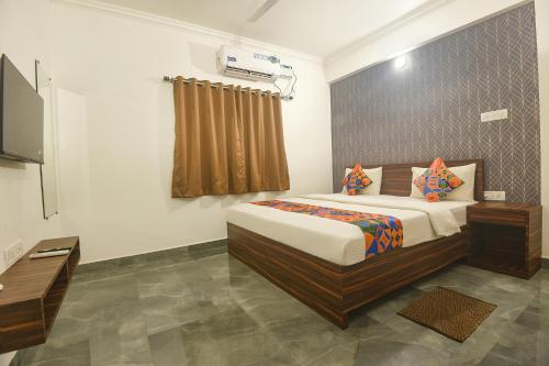 a bedroom with a bed and a television in it at FabExpress MA Homes in Morjim