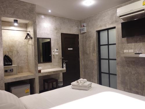 a bedroom with a bed and a sink and a mirror at Ritsurin Boutique Hotel - โรงแรมริทสุริน บูติค in Phuket Town