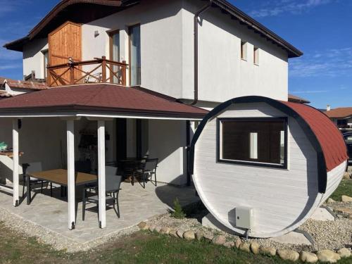 a large white house with a table and a roof at Къща за гости В 12 и 5 in Dolna Banya