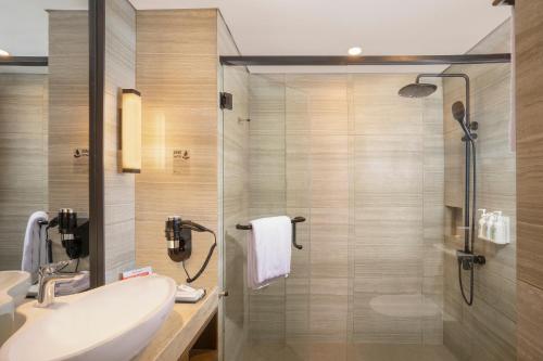 een badkamer met een douche, een wastafel en een toilet bij Swiss-Belhotel Airport Yogyakarta in Temon