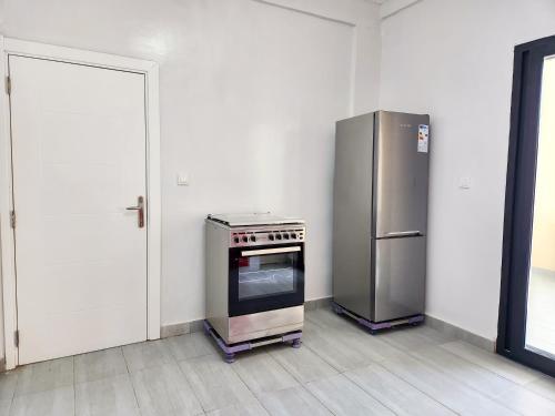 a kitchen with a stove and a refrigerator at F3 Appart Les Ambassades - Point E - Dakar in Dakar