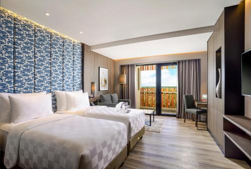 een hotelkamer met 2 bedden en een bureau bij Swiss-Belhotel Airport Yogyakarta in Temon