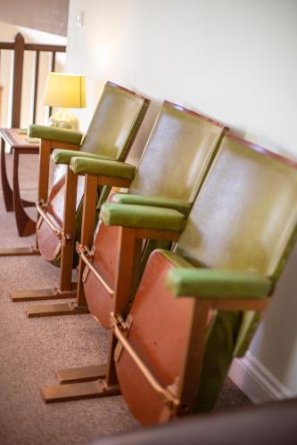 a row of green chairs sitting in a room at The Big Barn in Kidwelly