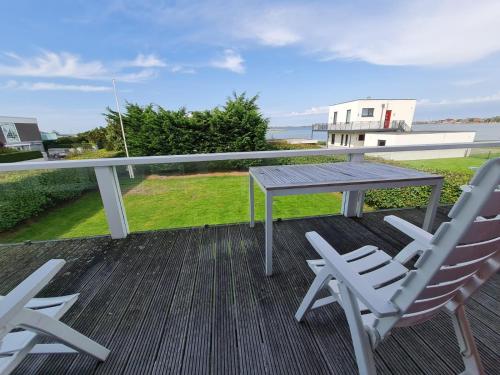 a table and chairs on a deck with a view of the ocean at Haus am Meer in Westfehmarn