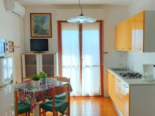 una cucina con tavolo, sedie e piano di lavoro di Residence Valbella Beach a Bibione