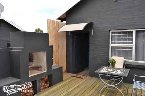 a patio with a fireplace and a table and chairs at Clarky's Bucketlist in Dullstroom