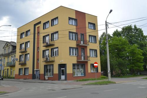 a yellow building on the corner of a street at apartament in Skarżysko-Kamienna