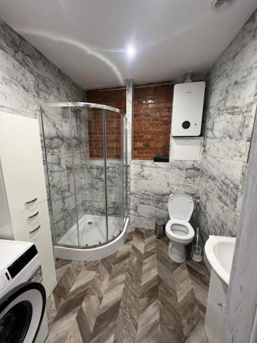 uma casa de banho com um chuveiro, um WC e um lavatório. em apartament em Skarżysko-Kamienna