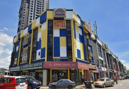 Sun Inns D2 @ Seri Kembangan في سيري كيمبانغان: مبنى فيه سيارات تقف في شارع المدينة
