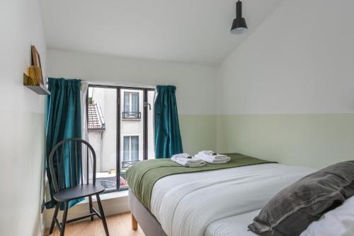 1 dormitorio con 1 cama y ventana con silla en Architect Loft - 15 min from city center - 8 guest, en Gentilly