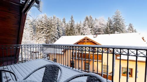 a balcony of a house with snow on the roof at Wonder Home - Apartamenty Karkonosz blisko wyciągów narciarskich, szlaków i restauracji in Karpacz